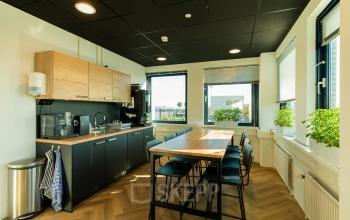 Moderne kantoorpand op Prins Willem Alexanderlaan 701, Apeldoorn, met een ingerichte kitchenette met zitgelegenheid, ideaal voor gezamenlijk gebruik of pauzes tijdens het werken. Geschikt voor kantoorruimte huren.