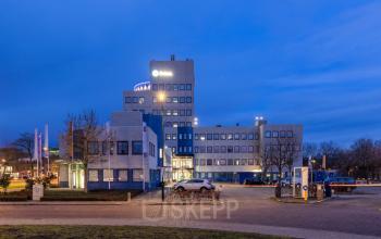 Modern kantoorpand op Prins Willem Alexanderlaan 701, Apeldoorn, met parkeerfaciliteiten op de voorgrond. Ideaal voor bedrijven die kantoorruimte willen huren in een toegankelijke omgeving.