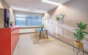Kantoorpand op Oude Apeldoornseweg 41-45 in Apeldoorn met een moderne vergaderruimte inclusief tafel, stoelen en planten. Ideaal voor wie kantoorruimte wil huren.