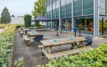 Kantoorpand op Oude Apeldoornseweg 41-45 in Apeldoorn met buitenruimte voorzien van picknicktafels en een overkapping. Ideaal voor kantoorruimte huren met ontspannen buitenomgeving.