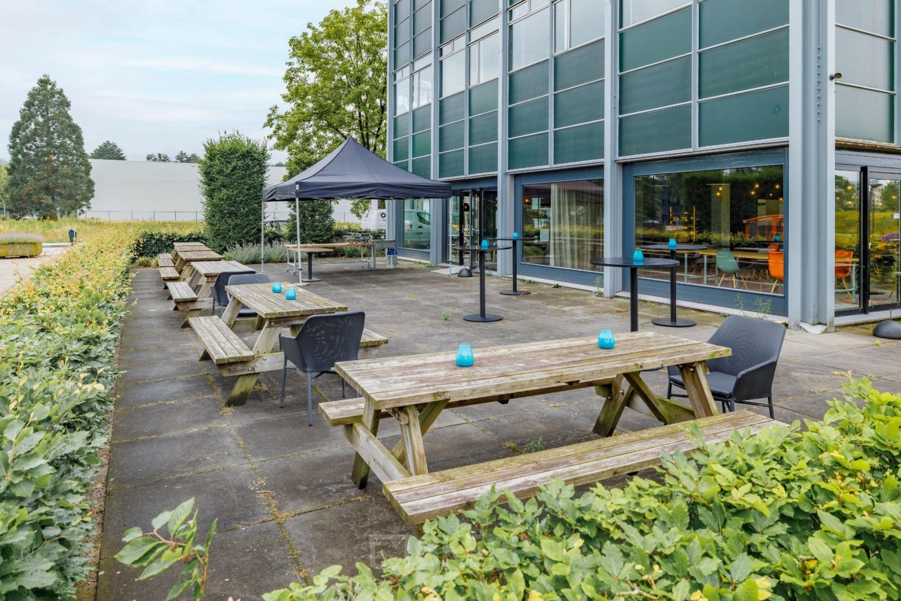Kantoorpand op Oude Apeldoornseweg 41-45 in Apeldoorn met buitenruimte voorzien van picknicktafels en een overkapping. Ideaal voor kantoorruimte huren met ontspannen buitenomgeving.
