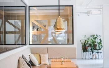 Gemeubileerde kantoorruimte huren aan Roggestraat 111, Apeldoorn, met moderne tafels en banken, en een rustige, lichte inrichting.