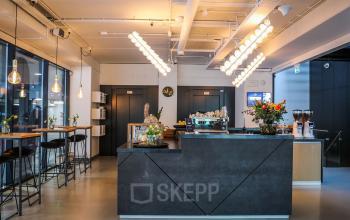 Moderne en goed verlichte kantoorruimte in kantoorpand aan Roggestraat 111, Apeldoorn, met een ruime zithoek en keukenfaciliteiten.