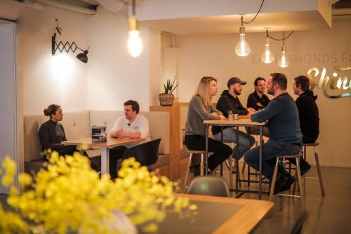 Gezellige kantine in het kantoorpand aan Roggestraat 111, Apeldoorn, met mensen die samen lunchen en praten aan tafels.