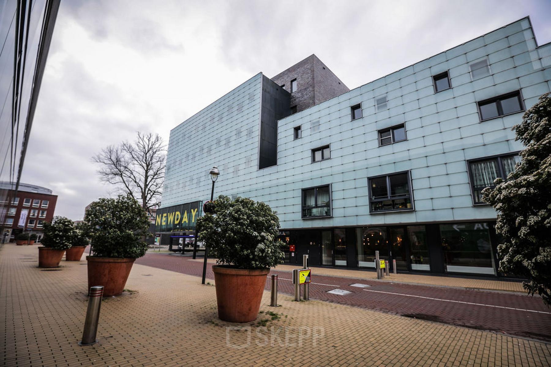 Kantoorpand aan de Roggestraat 111, Apeldoorn met moderne gevel en grote plantenbakken voor de entree.