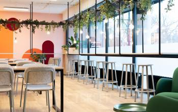 Moderne kantoorruimte met kleurrijke decoratie op de Jansbuitensingel 30 in Arnhem Centrum, inclusief comfortabel meubilair en planten.