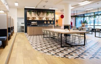 Modern ingerichte kantoorruimte met werkplekken en een bar op Jansbuitensingel 30 in Arnhem Centrum.