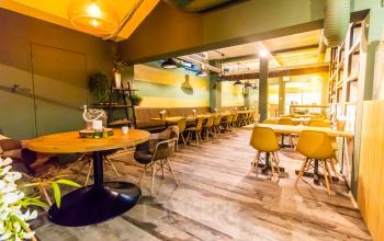 Gezellige kantoorruimte in Arnhem Centrum met houten tafels en comfortabele stoelen, ideaal voor kantoorruimte huren. Moderne verlichting en planten zorgen voor een inspirerende werkomgeving in het kantoorpand aan Jansbuitensingel 7.