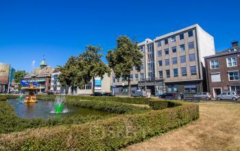 Buitenkant van een kantoorpand op Jansbuitensingel 7, Arnhem Centrum, gezien vanaf een tuin met fontein, geschikt voor kantoorruimte huren.