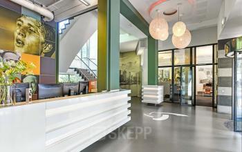 Moderne receptie in kantoorpand aan de Jansbuitensingel 7, Arnhem Centrum; biedt een indrukwekkende entree voor iedereen die kantoorruimte wil huren.