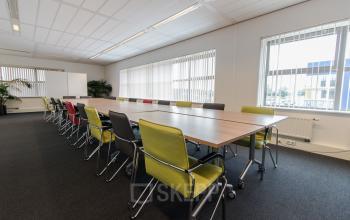 Modern ingerichte vergaderruimte binnen kantoorpand op Meander 251, Arnhem IJsseloord, met lange tafel en comfortabele stoelen.