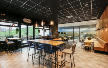 Kantoorruimte in Arnhem IJsseloord met een moderne, gemeubileerde open vloerplan. Grote ramen bieden veel lichtinval en uitzicht. Stoelen en tafels aanwezig voor vergaderingen of werkplekken. Delta 1 biedt comfort en functionaliteit.