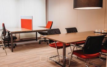 Gemeubileerde kantoorruimte op Vlamoven 34, Arnhem IJsseloord met vergadertafel, stoelen en werkplekken. Perfect voor het huren van kantoren in een moderne omgeving.