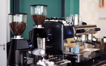 Koffiehoek in kantoorpand aan Mr D.U. Stikkerstraat 10 in Arnhem Zuid, met espressomachine en koffiemolens.