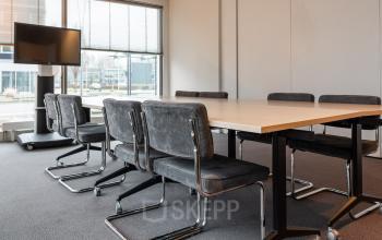 Vergaderruimte in kantoorpand aan Mr D.U. Stikkerstraat 10, Arnhem Zuid, met grote vergadertafel en zes stoelen.