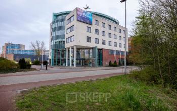 Moderne kantoorpand op Kronenburgsingel 525 in Arnhem Zuid, perfect voor kantoorruimte huren. Het gebouw heeft een glazen entree en meerdere verdiepingen, omgeven door groen.