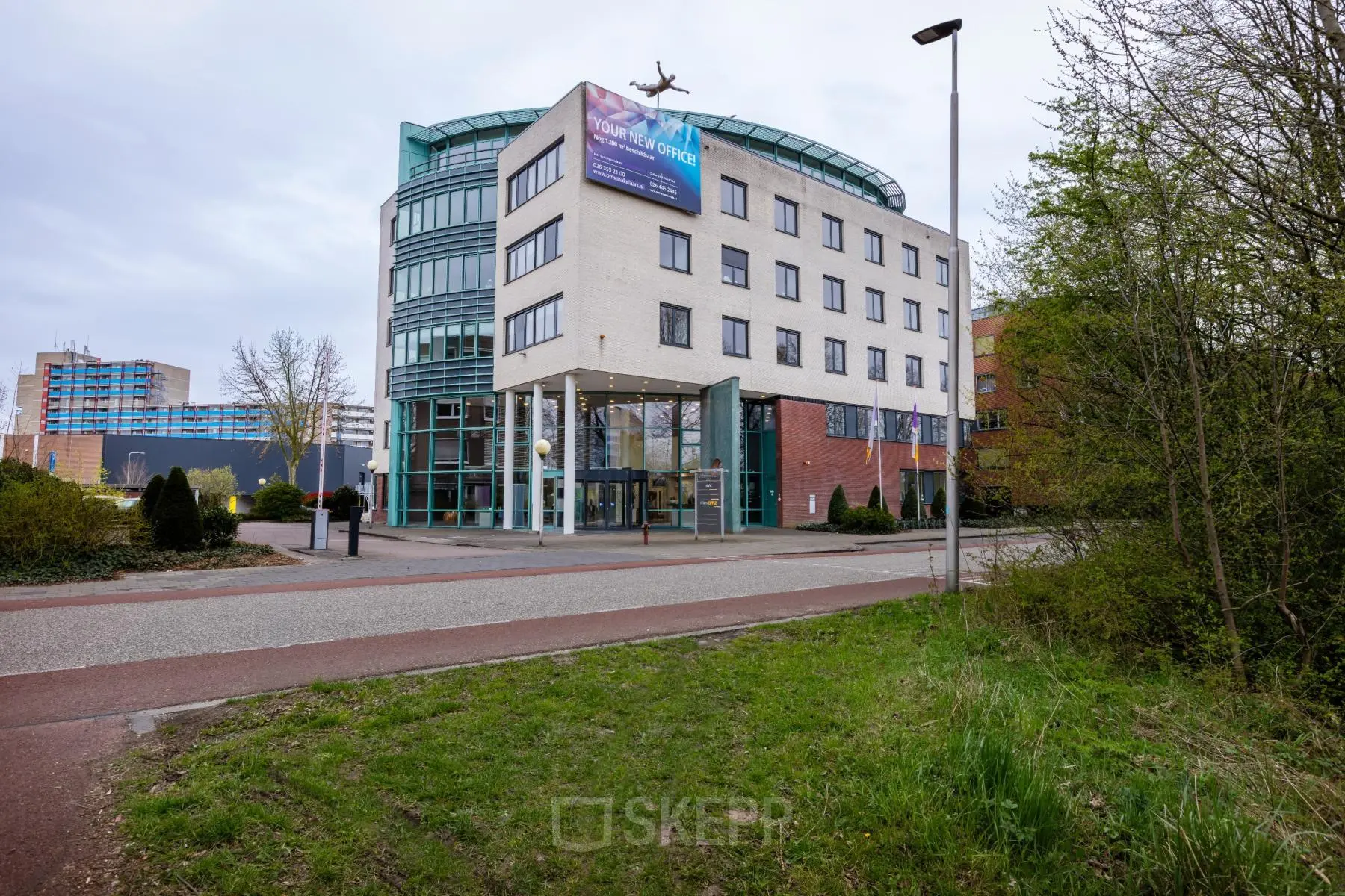Moderne kantoorpand op Kronenburgsingel 525 in Arnhem Zuid, perfect voor kantoorruimte huren. Het gebouw heeft een glazen entree en meerdere verdiepingen, omgeven door groen.
