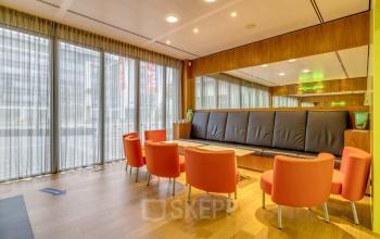 Kantoorpand op Meester D.U. Stikkerstraat 11 in Arnhem Zuid met vergadertafel en felgekleurde stoelen.