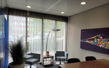 Ontspannen kantoorpand op Meester D.U. Stikkerstraat 11, Arnhem Zuid met moderne inrichting. Strakke vergaderruimte met comfortabele stoelen en een kunstwerk aan de muur.