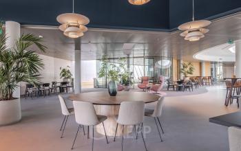 Moderne, open werkruimte in het kantoorpand op Rijksweg-West 2, Arnhem Zuid, met stijlvolle meubels en veel groenvoorziening.