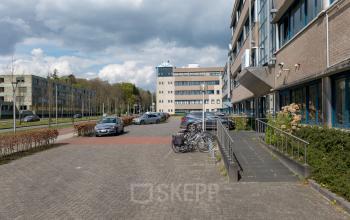 Buitenzijde van het kantoorpand op Overcingellaan 17, Assen, met parkeerplaatsen en fietsenstalling. Ideaal voor bedrijven die kantoorruimte willen huren in een goed bereikbare omgeving.