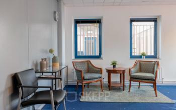 Interieurfoto van een kantoorpand aan de Overcingellaan 17 in Assen met een bescheiden zithoek, verlichte ruimte en uitzicht op buiten. Ideaal voor bedrijven die op zoek zijn naar kantoorruimte huren.