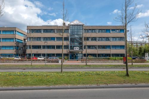 Exterieur van kantoorpand aan de Overcingellaan 17 in Assen, vier verdiepingen hoog met symmetrische raampartijen. Ideale locatie voor kantoorruimte huren met goede parkeermogelijkheden voor de deur.