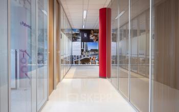 Heldere kantoorruimte in Baarn met glazen wanden en een rode kolom, gelegen aan Amalialaan 126. De ruimte biedt mogelijkheden voor kantoorruimte huren met een functionele uitstraling.