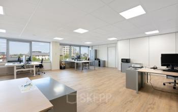 Kantoorruimte huren bij Kamerlingh Onnesweg 10 in Barendrecht, met werkplekken en grote ramen waardoor veel licht binnenvalt. Het kantoorpand biedt zicht op omliggende gebouwen met moderne werkstations.