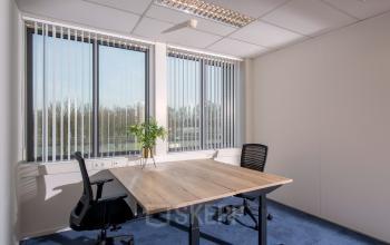 Lichte kantoorruimte huren aan Veemweg 29-31 in Barneveld met twee bureaustoelen en een houten tafel voor een productieve werkomgeving.