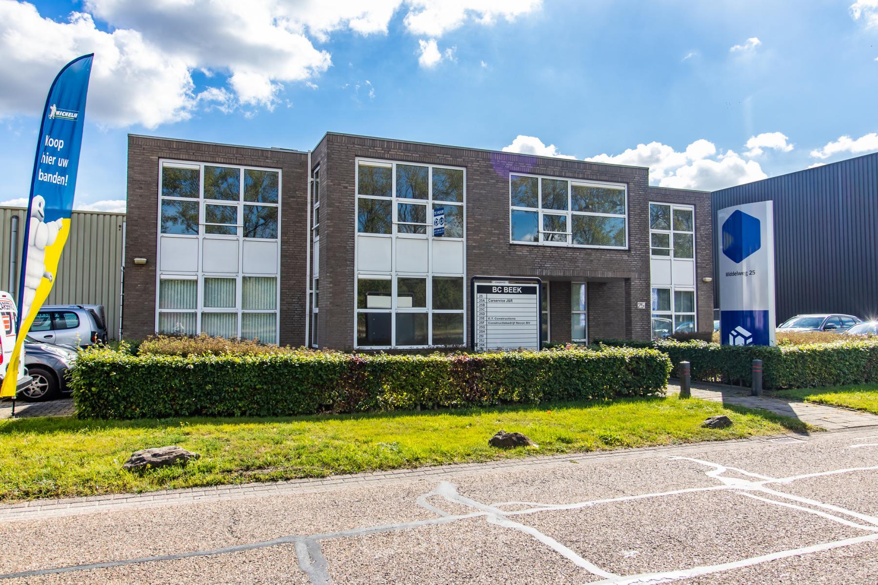 Vooraanzicht van het kantoorpand op Middelweg 25 in Beek Lb, moderne gevel met grote ramen en goed onderhouden groenvoorziening.