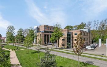 Exterieur van kantoorpand Rijtuigweg 10 in Bergen op Zoom, met groene omgeving en parkeerplaatsen. Ideale locatie voor kantoorruimte huren in moderne setting.