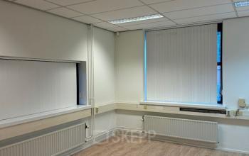 Ongemeubileerd kantoorpand op Rijtuigweg 10, Bergen op Zoom, met witte muren en houten vloer. Ideale kantoorruimte huren met simpele vensterblinds en tl-verlichting.