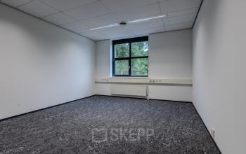 Ongemeubileerd kantoor op Rijtuigweg 10 in Bergen op Zoom met tapijt, witte muren en een raam. Een ruimte ideaal voor kantoorruimte huren of andere zakelijke activiteiten.