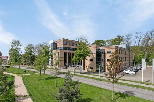 Exterieur van kantoorpand Rijtuigweg 10 in Bergen op Zoom, met groene omgeving en parkeerplaatsen. Ideale locatie voor kantoorruimte huren in moderne setting.