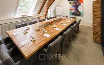Vergaderruimte in kantoorpand Blokstallen 2B, Bergen op Zoom, met lange houten tafel en comfortabele stoelen, geschikt voor kantoorruimte huren.