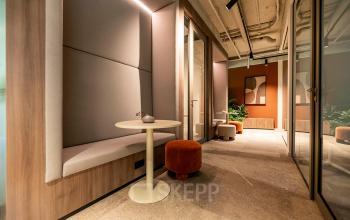 Stijlvol interieur van een modern kantoorpand aan De Maas 8 in Best, met een uitnodigende zithoek en warme tinten. Ideaal voor wie kantoorruimte wil huren met een professionele uitstraling.