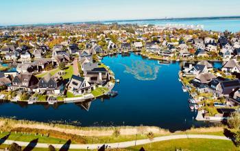 Uitzicht op een schilderachtige woonwijk in Blaricum met veel water en groene ruimte, te zien vanaf DeltaZijde 20b.