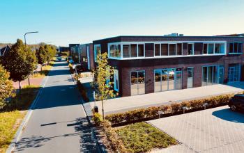 Kantoorpand aan Deltazijde 20b in Blaricum, omringd door groen en parkeerruimte, ideaal voor bedrijven die kantoorruimte willen huren. Het gebouw heeft strakke, moderne lijnen en biedt een professionele uitstraling.
