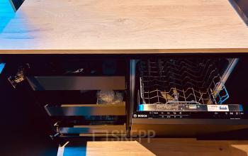 In de kantoorruimte op Deltazijde 20b in Blaricum zie je een keukenblok met open kastjes en een vaatwasser. Ideaal voor huurders die tijdens het werken gebruik willen maken van keukenfaciliteiten.