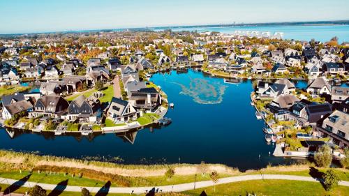 Uitzicht op een schilderachtige woonwijk in Blaricum met veel water en groene ruimte, te zien vanaf DeltaZijde 20b.