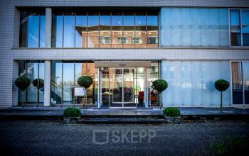 Het kantoorpand aan Tolnasingel 1-3 in Bodegraven heeft een moderne glazen gevel en een uitnodigende entree.