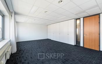 Kantoorruimte te huur aan Tolnasingel 1 - 3 in Bodegraven met zwart tapijt en witte muren. Geschikt voor verschillende indelingen en toepassingen.