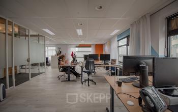 Open kantoorruimte huren in Bodegraven, Tolnasingel 1 - 3, met werkplekken en enkele medewerkers aan het werk achter hun computers.