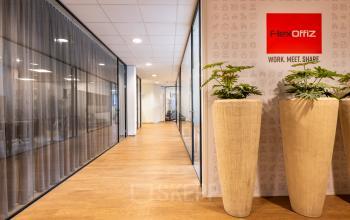 Stijlvolle kantoorpand hal op Marktstraat 1-7, Bodegraven met moderne glazen wanden en planten. Beschikbaar voor kantoorruimte huren met een professioneel en uitnodigend ontwerp.