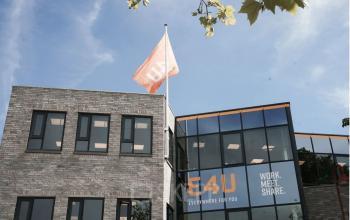 Moderne gevel van kantoorpand aan Marktstraat 1-7 in Bodegraven met vlag en glazen entree.