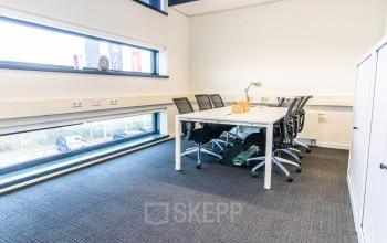 Lichte kantoorruimte te huur op Ceresstraat 1 in Breda Centrum-Station met grote ramen, moderne bureaus en stoelen, geschikt voor zakelijke activiteiten.