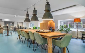 Moderne kantoorruimte op Ceresstraat 13, Breda Centrum-Station, met een grote houten tafel, stijlvolle stoelen en veel natuurlijk licht, ideaal voor kantoor verhuur en gebruik.