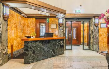 Inviting reception area in a kantoorpand at Ceresstraat 13, Breda Centrum-Station, perfect for kantoorruimte huren. Elegant design with marble details and warm lighting.