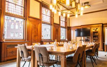 Stijlvolle vergaderruimte in het kantoorpand op Ceresstraat 13, Breda Centrum-Station, met houten lambrisering en grote ramen.